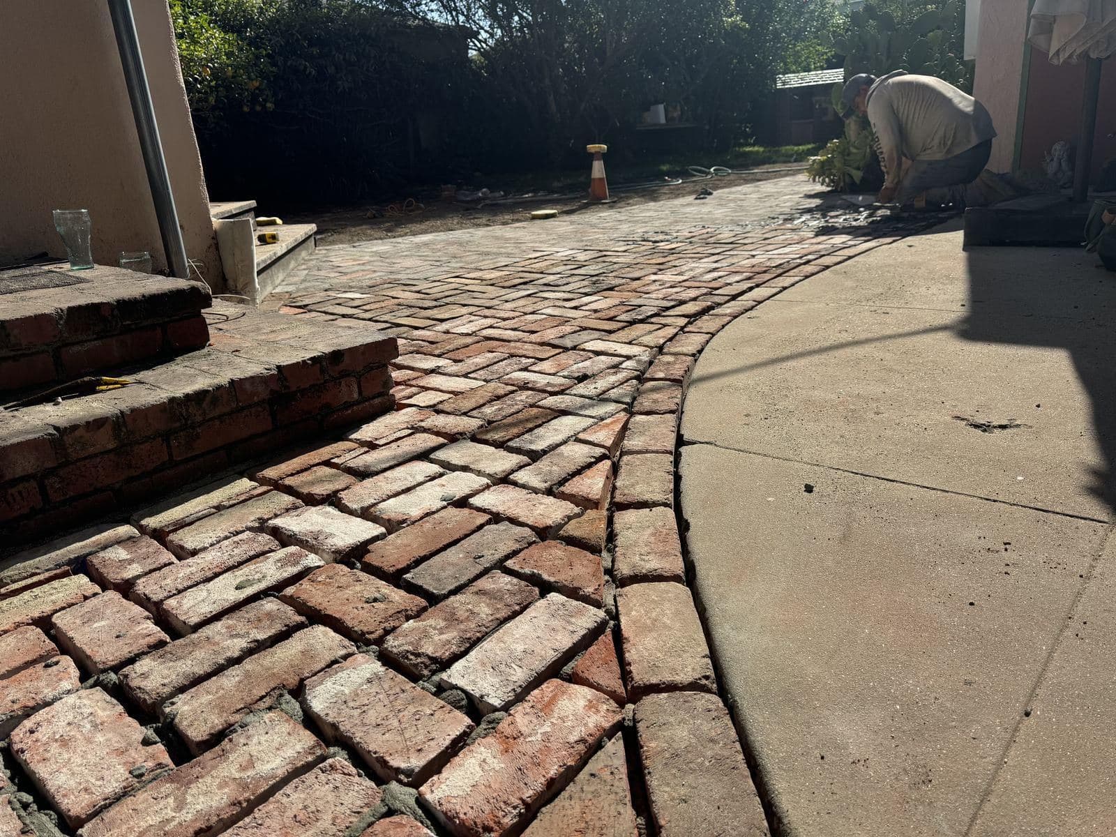 Finished reclaimed brick walkway curving through a backyard