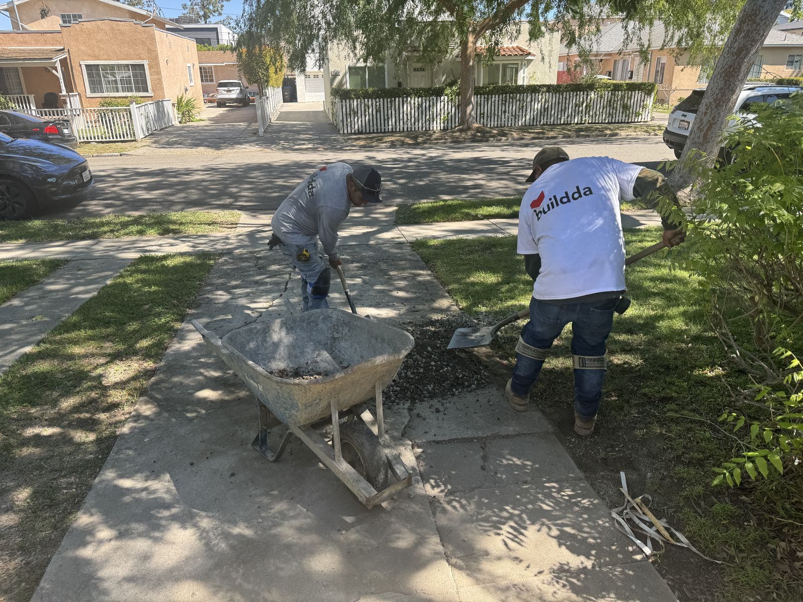 Buildda crew working with wheelbarrow in Culver City side yard during brick walkway project