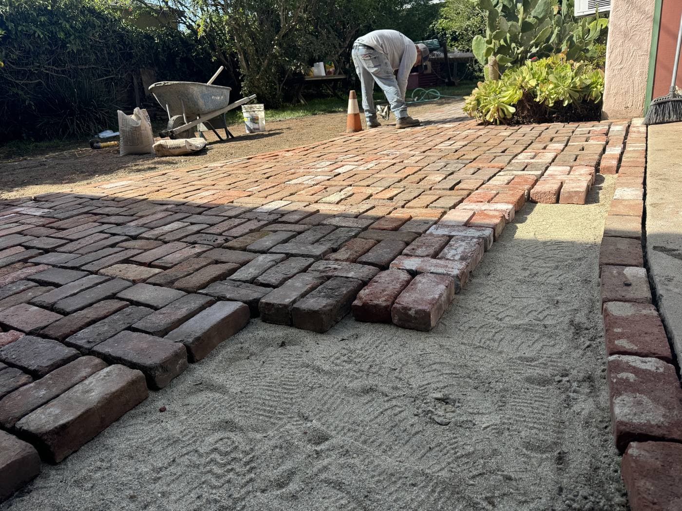 Partially complete reclaimed brick walkway showing pattern emerging in Culver City backyard project