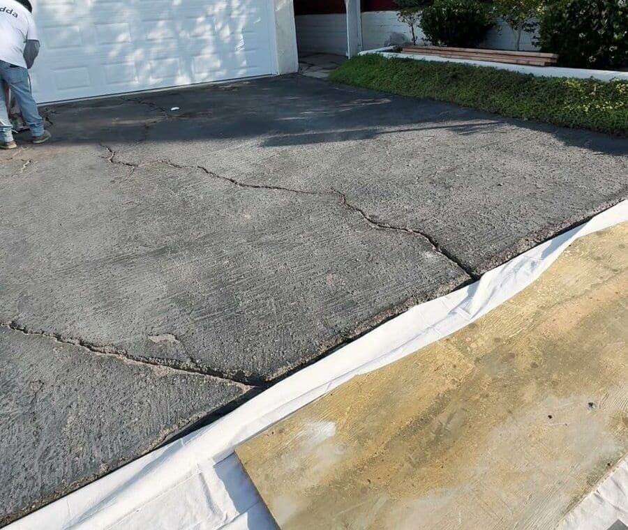 Cracked asphalt driveway in Culver City before Buildda replaced it with concrete