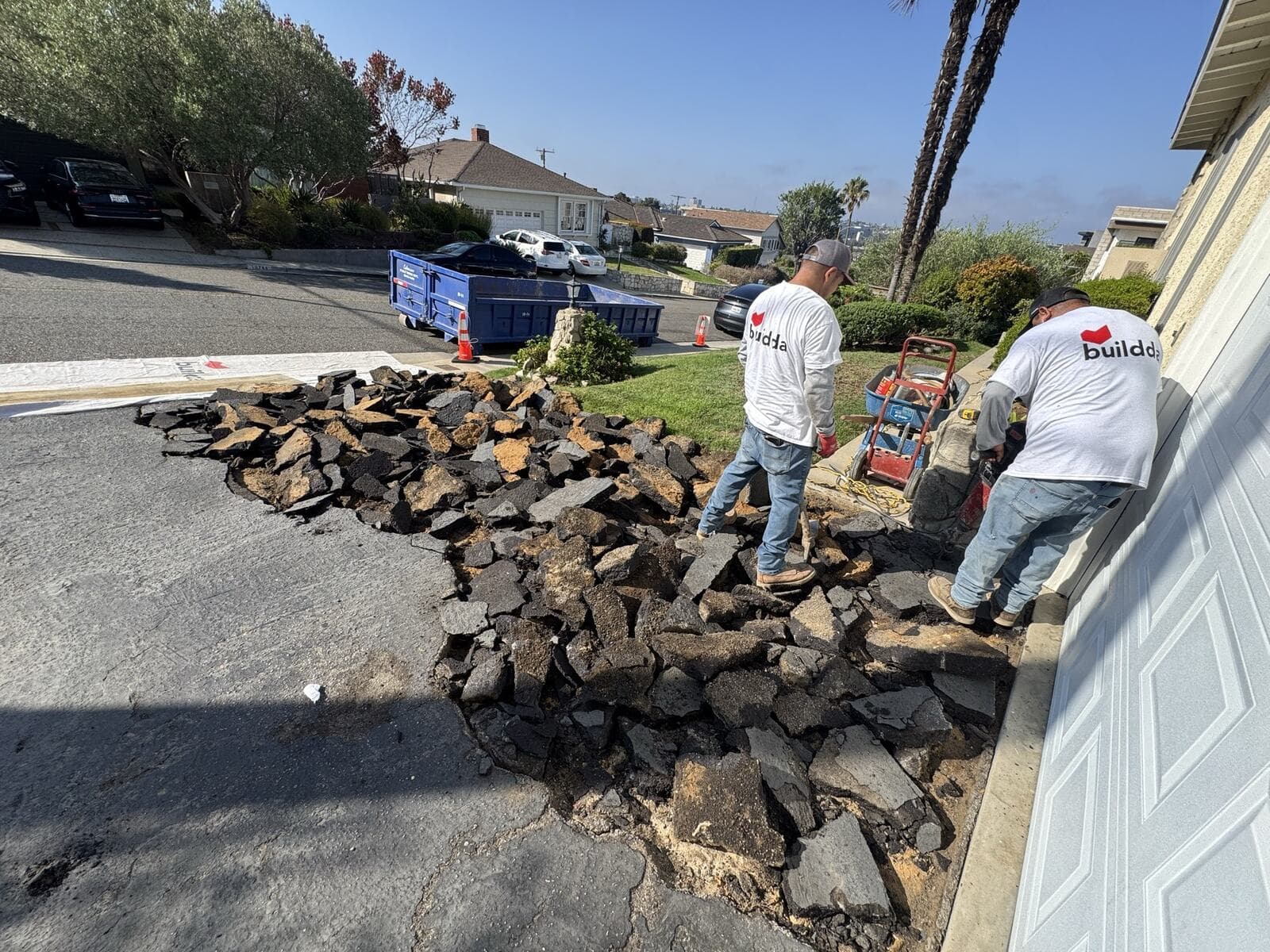 Crew breaking out and removing the old asphalt driveway during demolition in Culver City