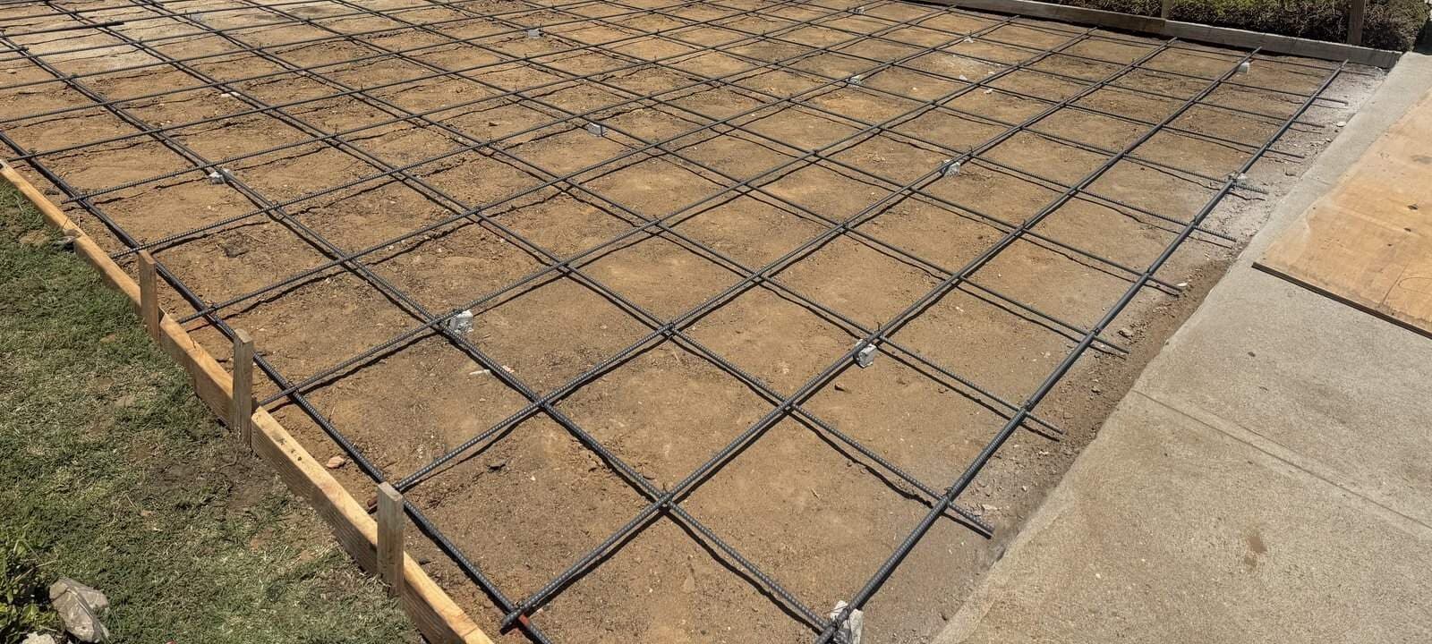 Steel grid set on the prepared driveway base before the concrete pour in Culver City