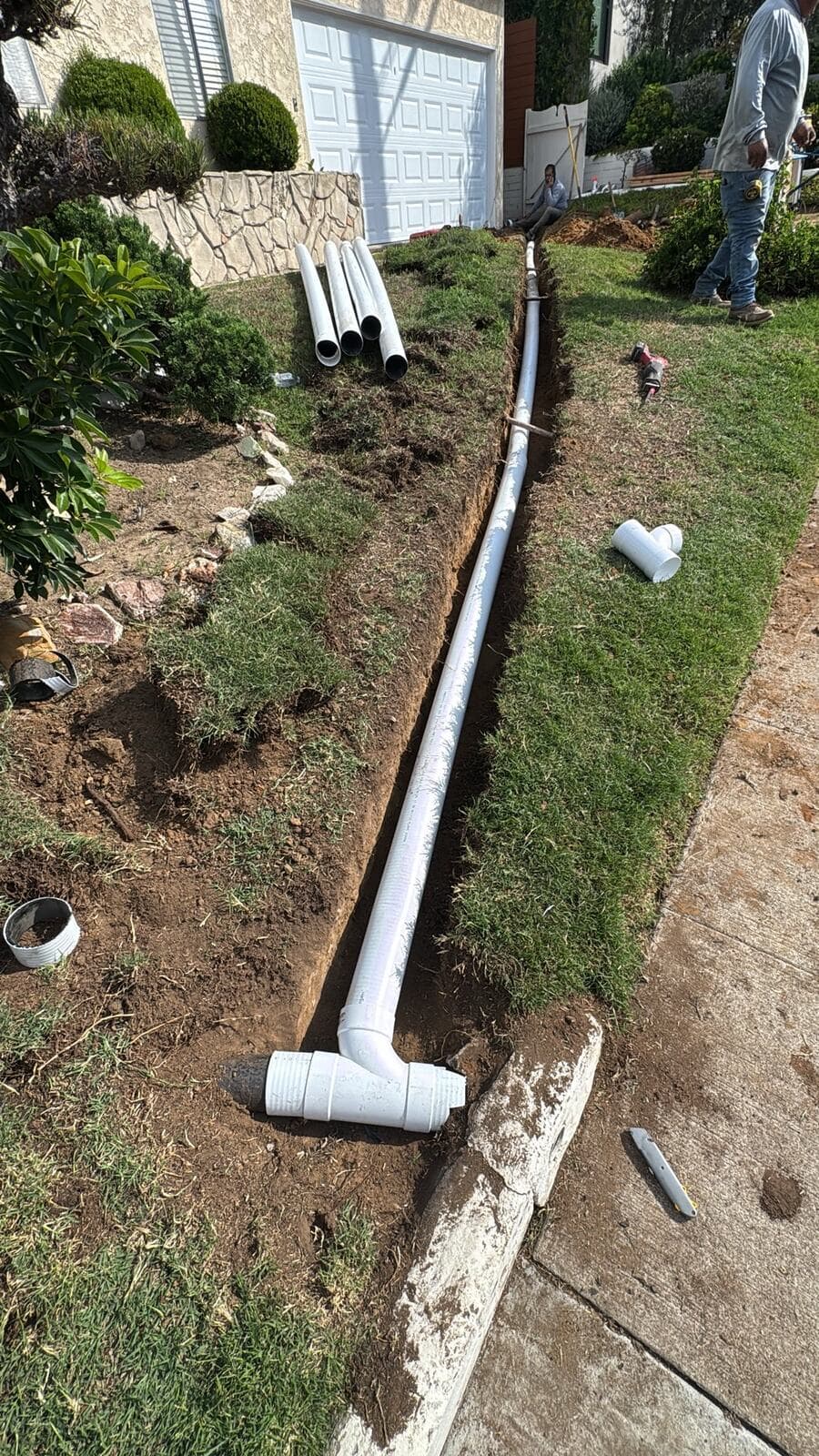 New drain pipe laid in the trench running toward the street in Culver City