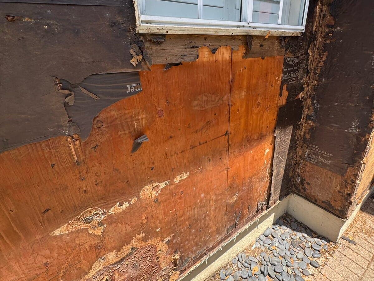 Rotted sheathing exposed below a window after the old wood siding came off a Palms home
