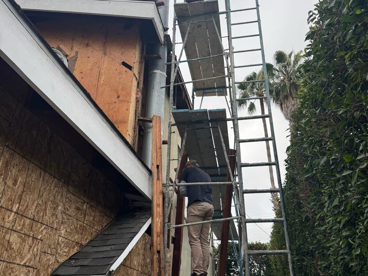Crew installing new sheathing on the upper wall from scaffolding on a Palms siding job