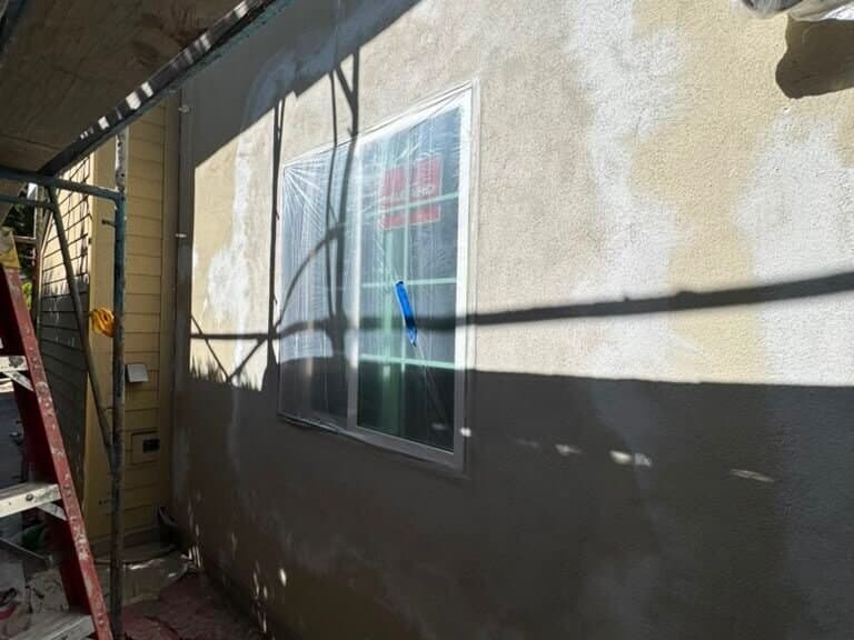 Stucco patched around a new window opening before painting on a Palms exterior job
