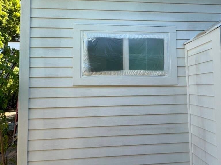 New siding and window trim primed white before the final color on a Palms home