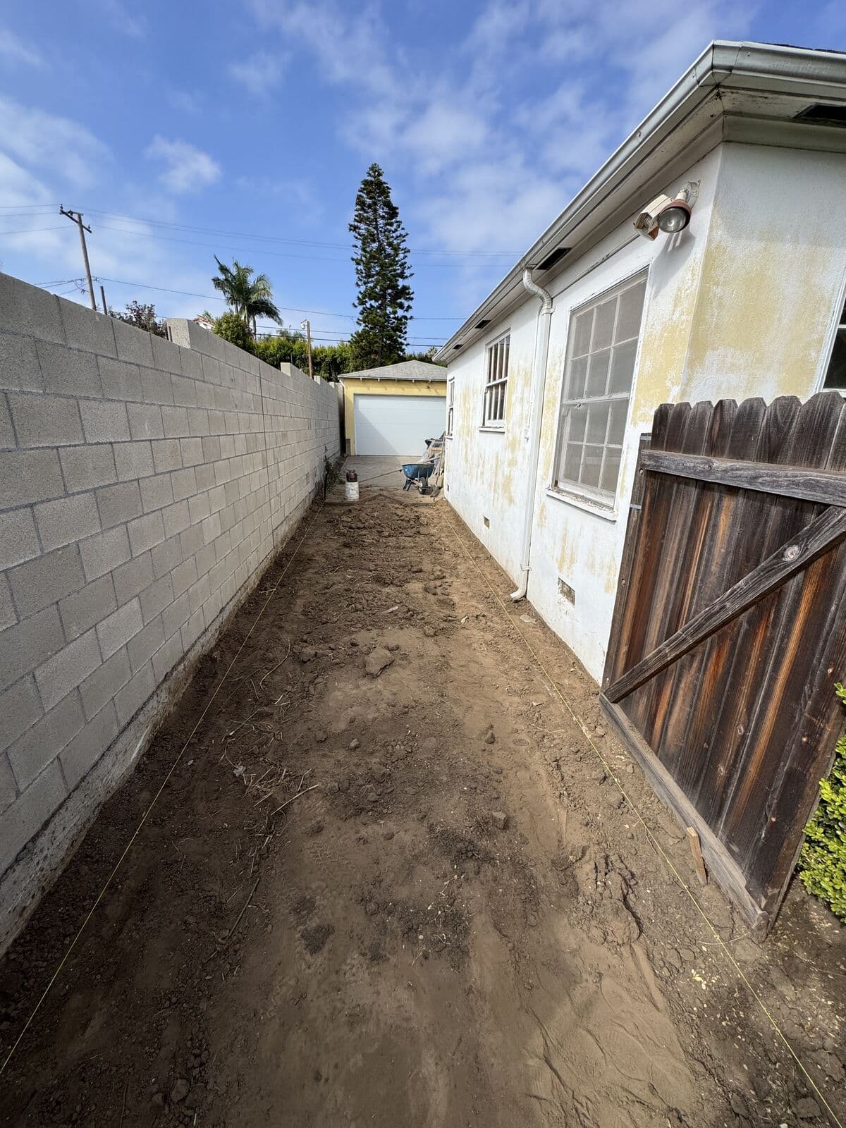 Side yard excavated and graded for the base of a new concrete driveway in Santa Monica
