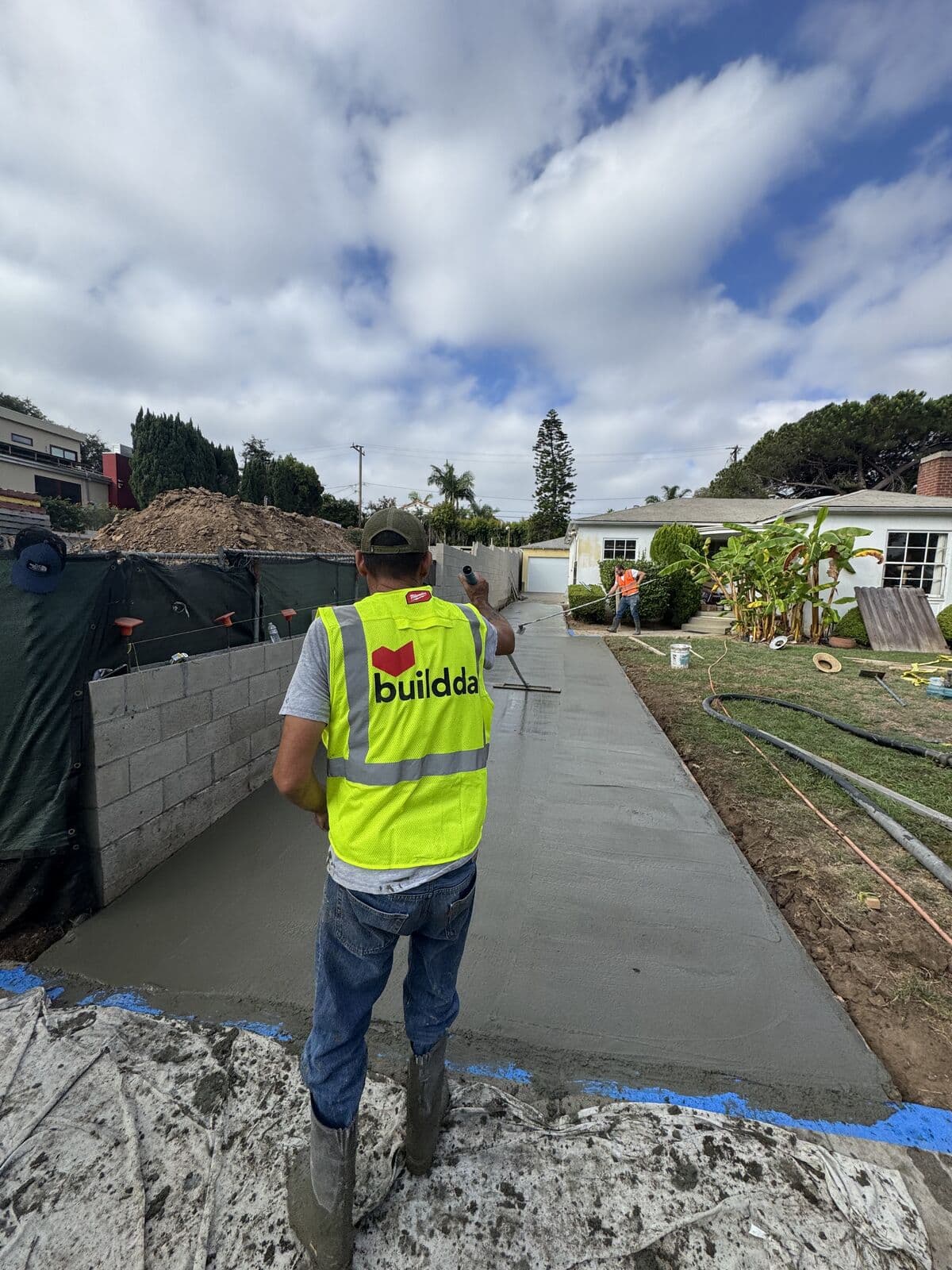 Buildda crew member on pour day beside a freshly poured concrete driveway in Santa Monica