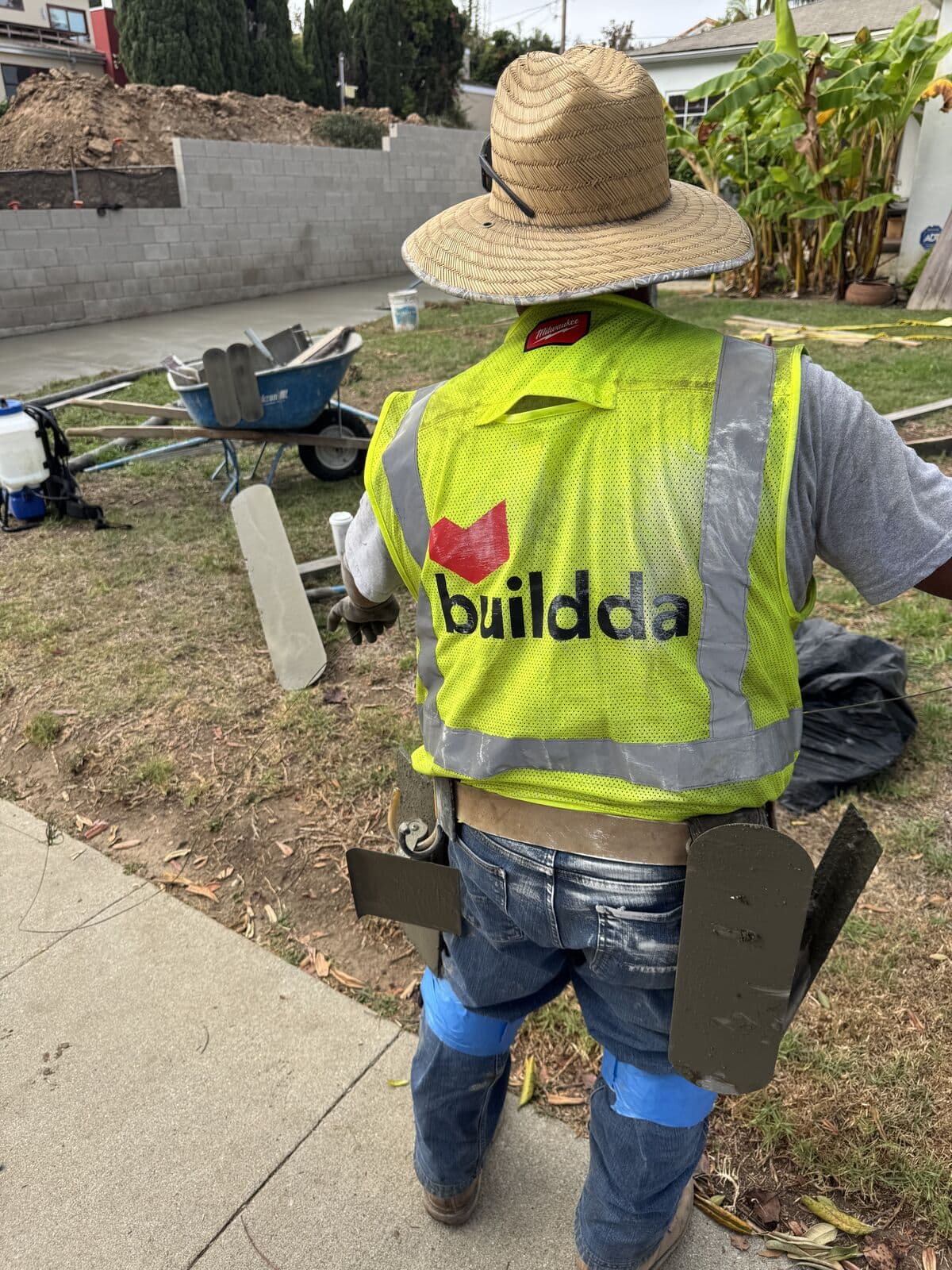 Buildda crew member with finishing tools and kneeboards on a new Santa Monica driveway