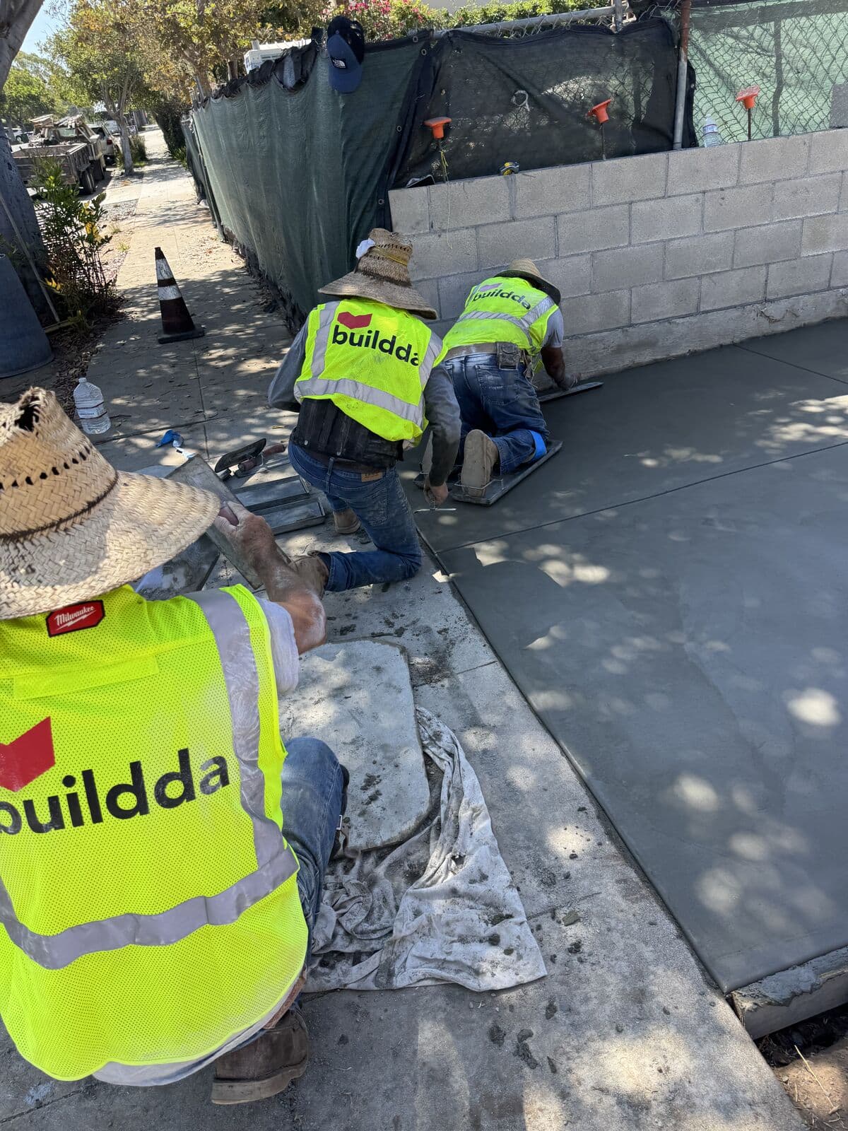 Buildda crew finishing the street end of a new concrete driveway in Santa Monica