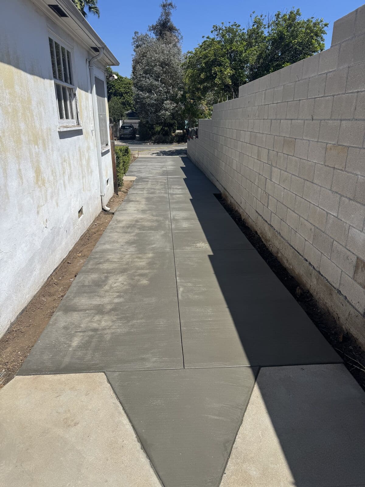 Finished concrete driveway with control joints and a broom finish along a Santa Monica home